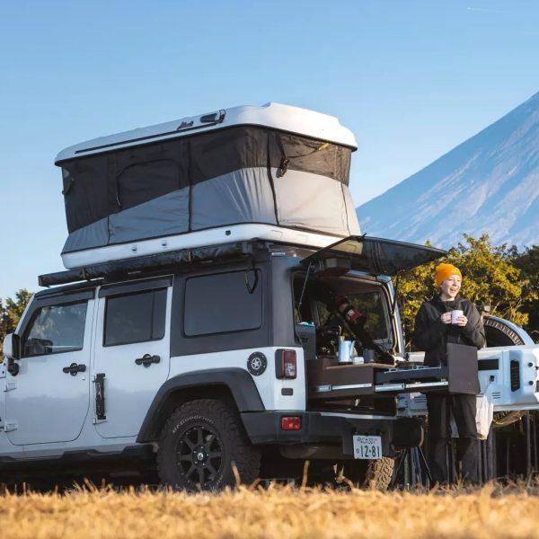 Fully opened family-size fiberglass hard shell roof top tent with 360-degree panoramic windows and hydraulic pop-up mechanism.