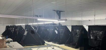 Two rows of finished clamshell triangular rooftop tents undergoing quality inspection in our direct manufacturing facility.