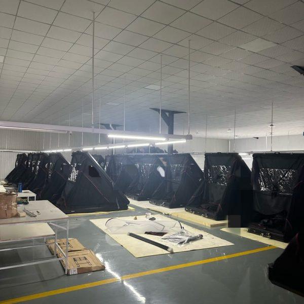Two rows of finished clamshell triangular rooftop tents undergoing quality inspection in our direct manufacturing facility.