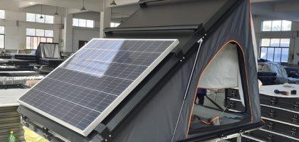 Custom hard shell rooftop tent with integrated solar panel for off-grid power.