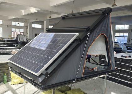 Custom hard shell rooftop tent with integrated solar panel for off-grid power.