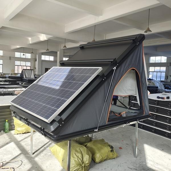 Custom hard shell rooftop tent with integrated solar panel for off-grid power.