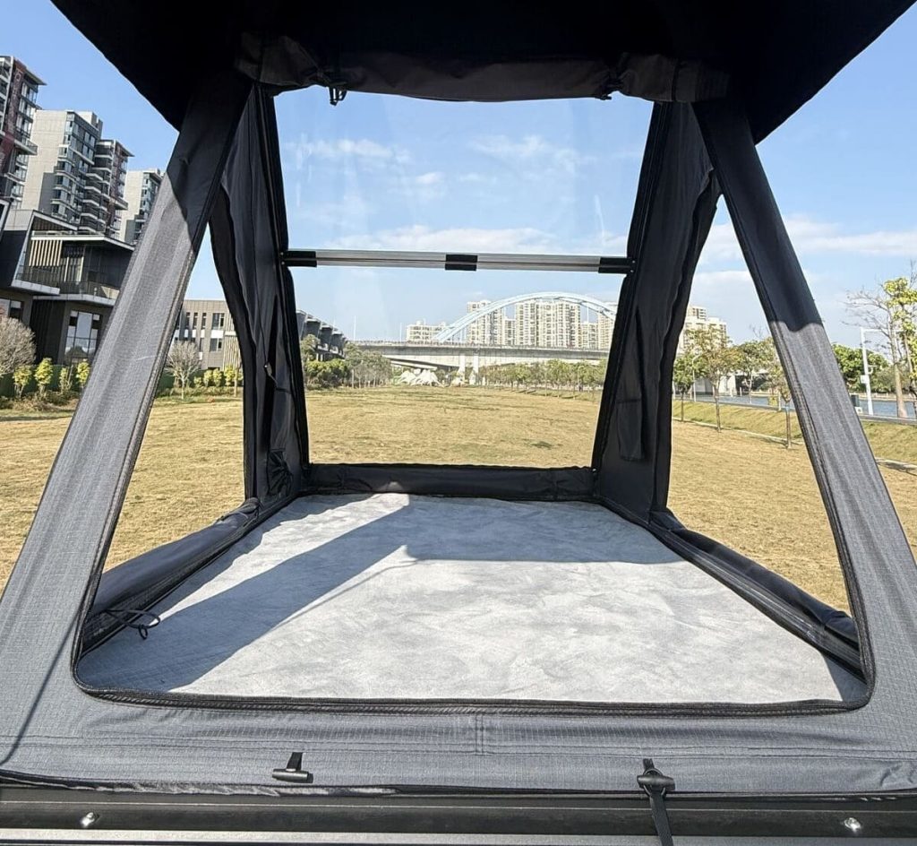 A high-end triangular hard-shell rooftop tent from the Stargazing Series, fully deployed on a 4x4 vehicle. The clear upper cover allows for an immersive, panoramic view of the night sky, ideal for stargazing.